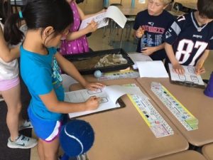 Second grade students test different solutions to solving the problem of erosion.